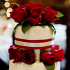 Romantic four-tiered cake with red ribbon and roses